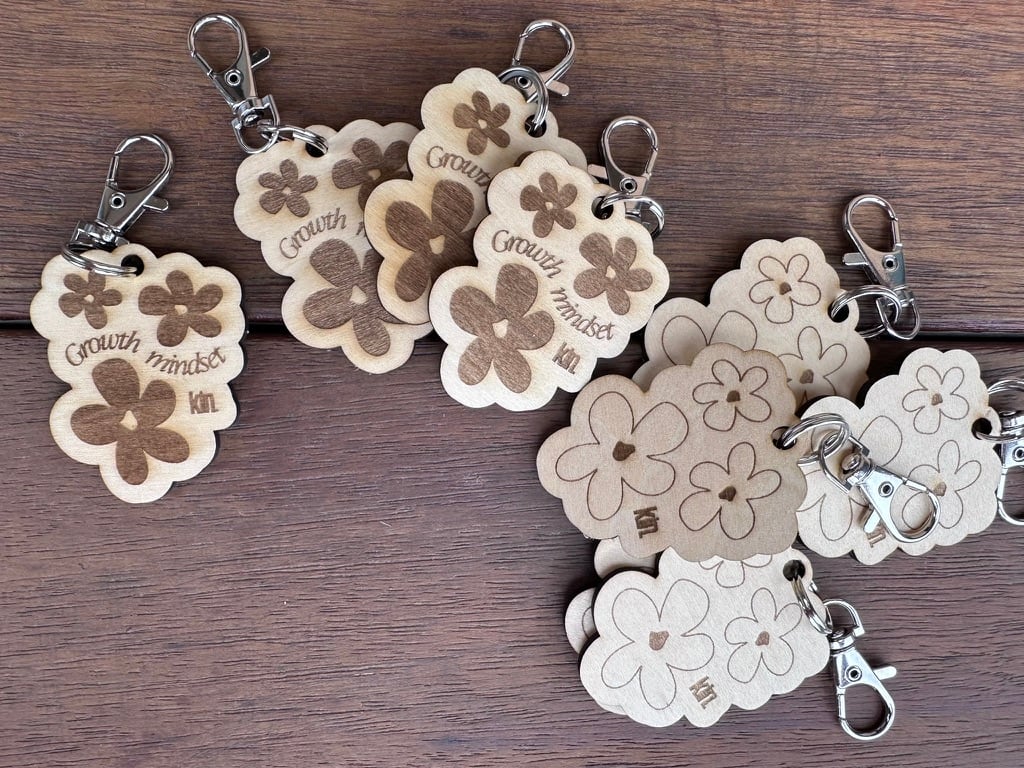 A collection of wooden Growth Mindset keyrings designed for Kin