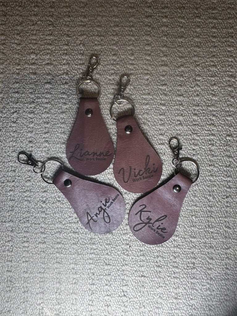 Four personalised brown leather keytags engraved with names
