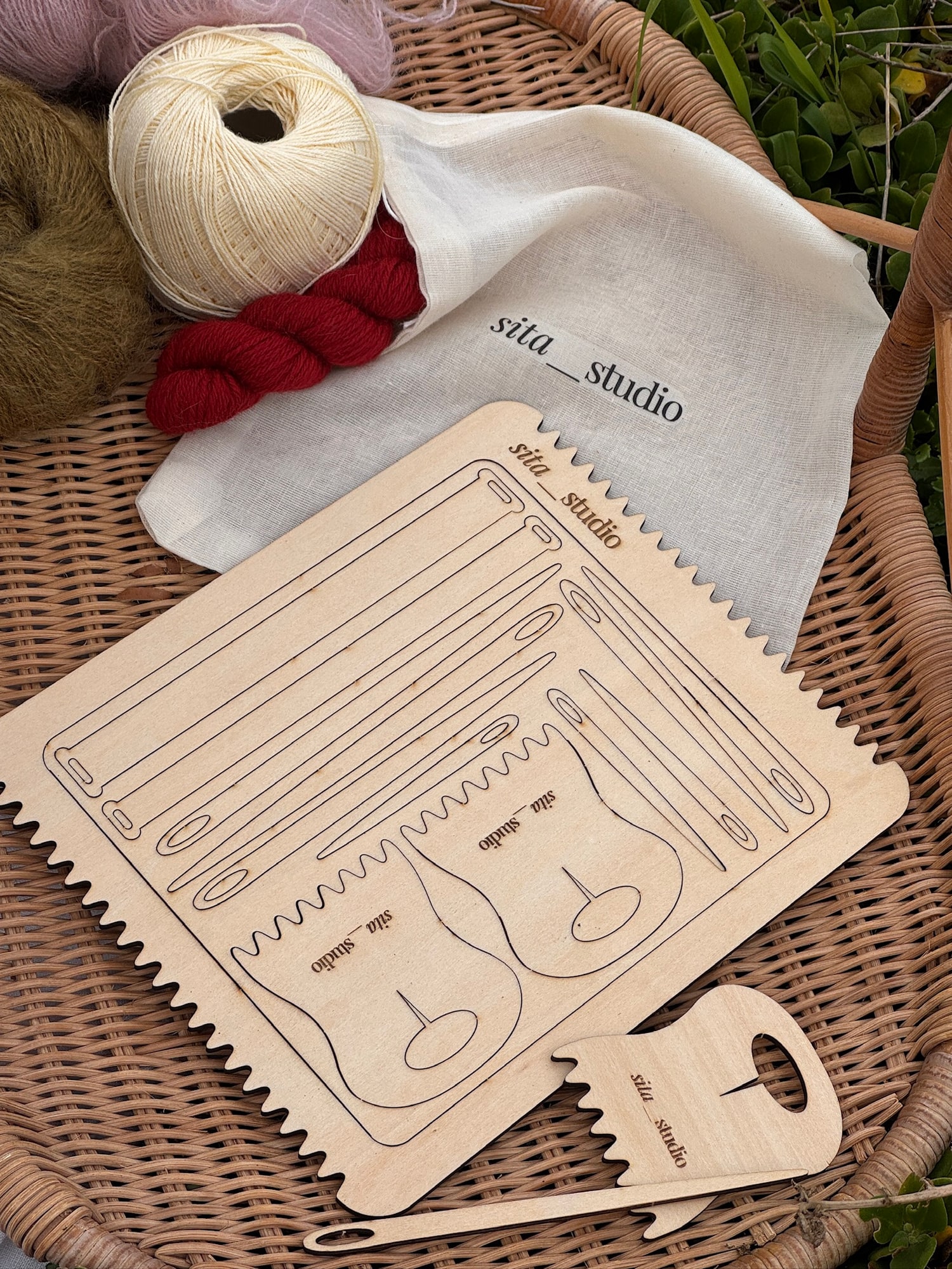Sita Studio branded wooden weaving loom and fabric bag styled with yarn in a wicker basket