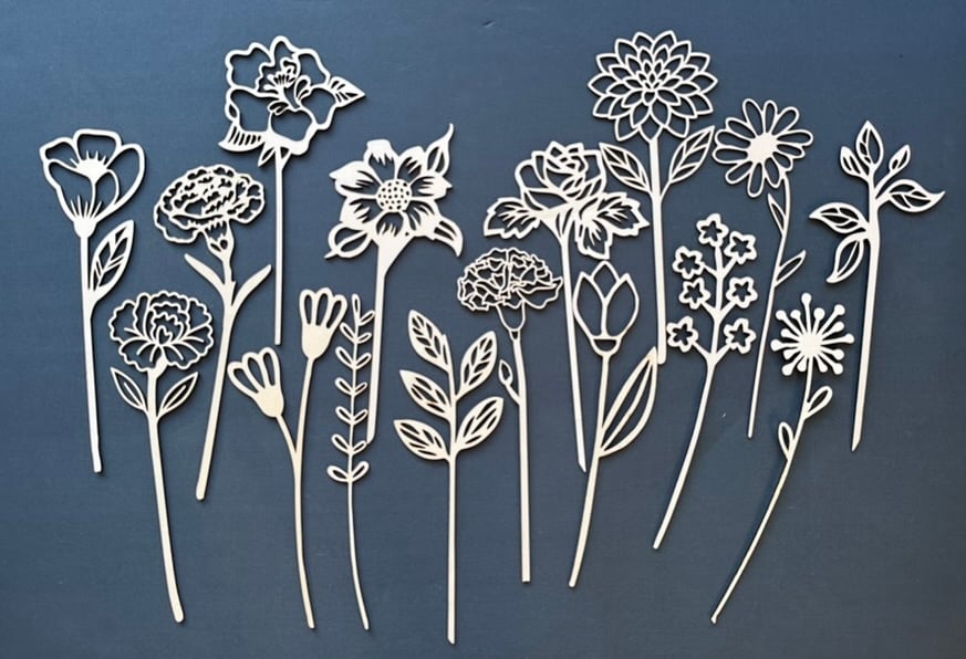 A collection of delicate laser-cut wooden flower shapes